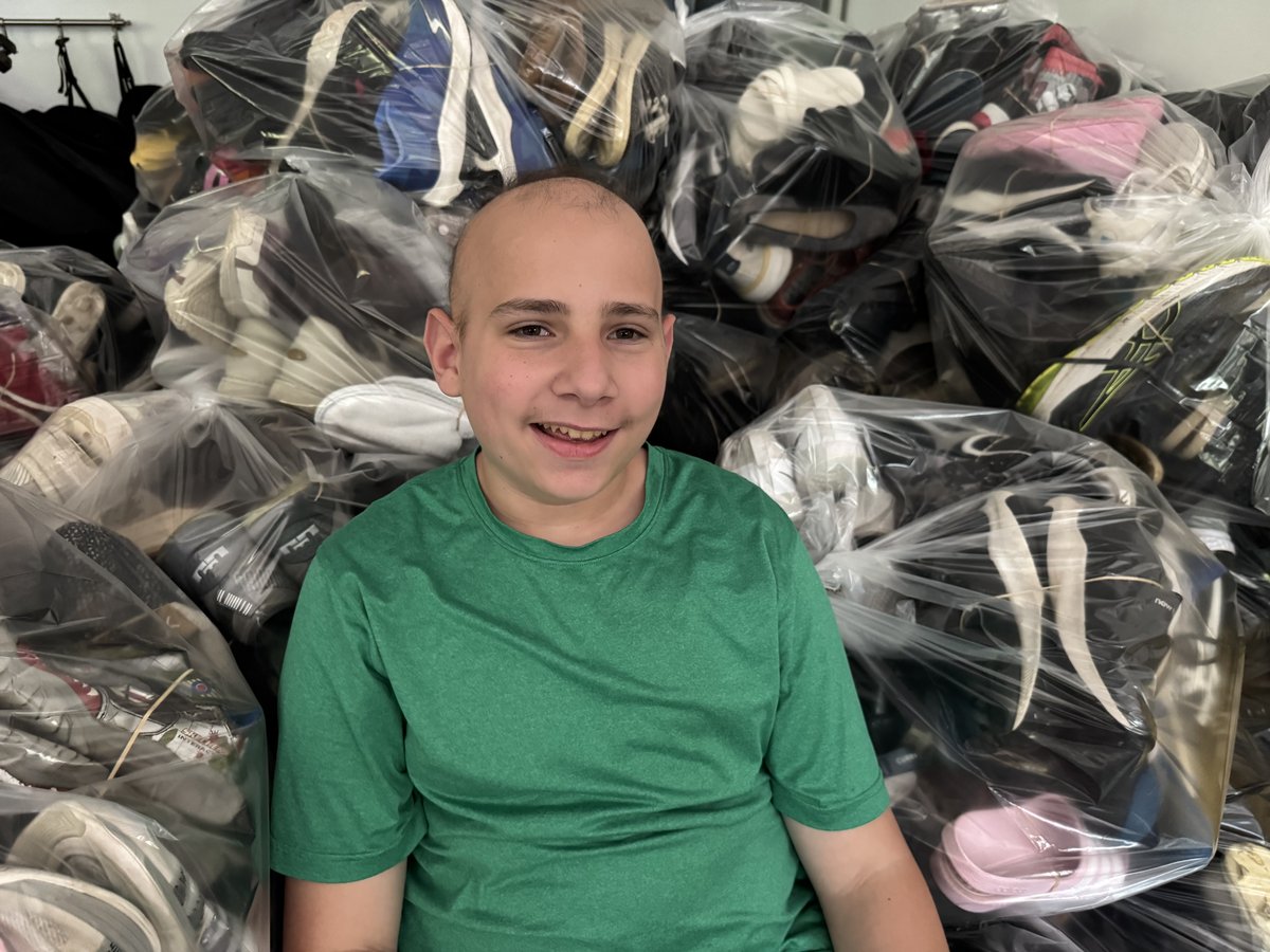 Logan Shenker with bags of shoes collected for the Shoe Drive